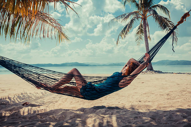 istock Woman relaxing in hammock on tropical beach 466813580