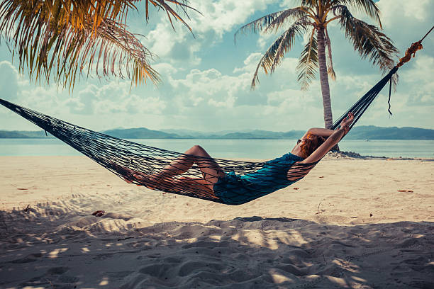 istock Woman relaxing in hammock on tropical beach 466813986