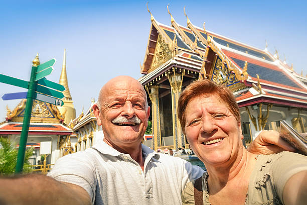 senior glückliches paar, die selfies in großer palast tempel bangkok - wat blue ancient old stock-fotos und bilder