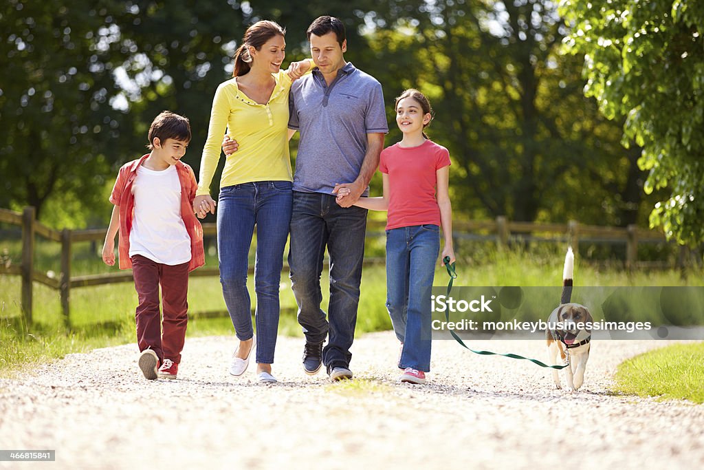 Hispanic Family Taking Dog For Walk In Countryside Hispanic Family Taking Dog For Walk In Countryside On Summers Day Family Stock Photo