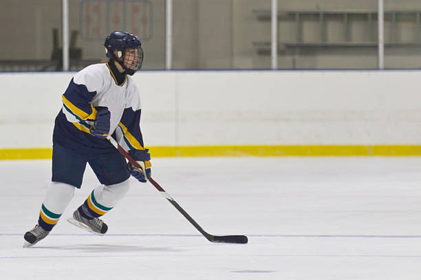 Female ice hockey player skating during a game stock photo