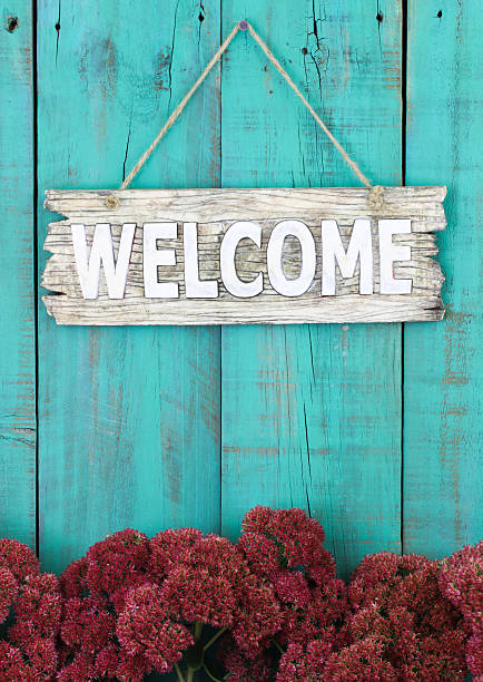 istock Welcome sign hanging on fence with stonecrop border 466818682