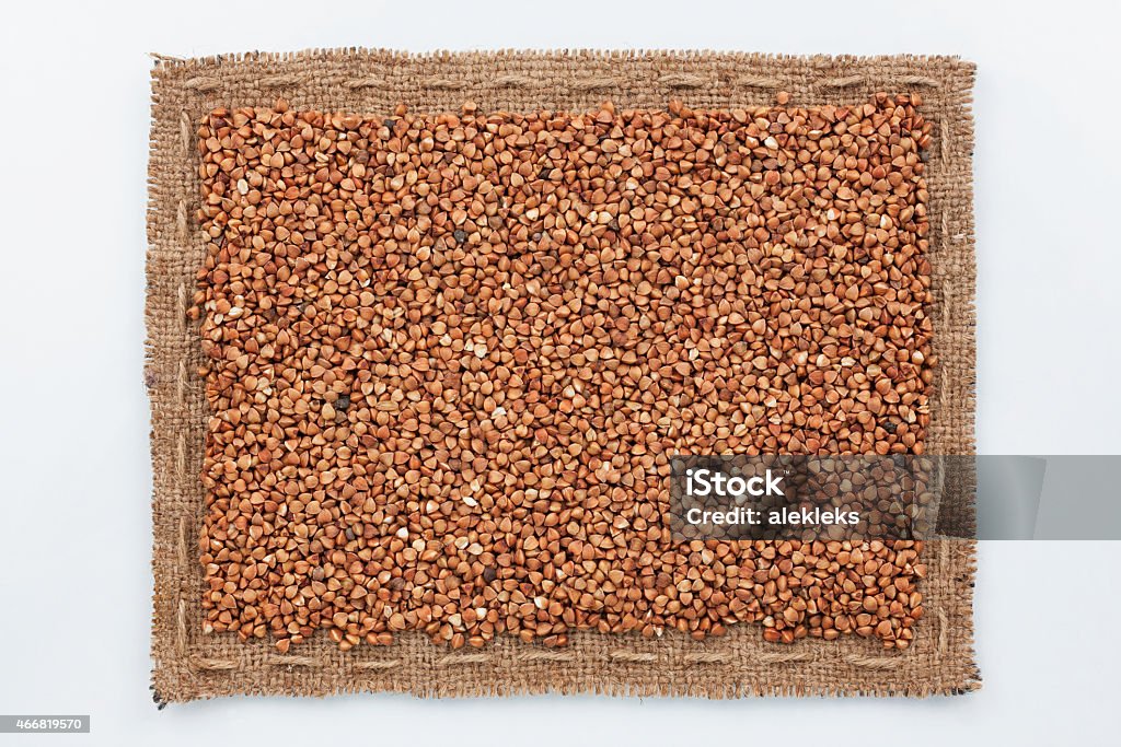 Frame of burlap and  buckwheat  grain Frame of burlap and  buckwheat  grain, lying on a white background 2015 Stock Photo