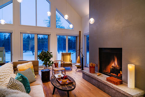 Collingwood Cottage Open Concept Interior North American Cottage interior. Main floor open area of winter home North of Toronto, Canada. Featuring large windows with view of surrounding area, grand fireplace and modern mix of furniture and fabrics from around the world. modern cottage interior design stock pictures, royalty-free photos & images
