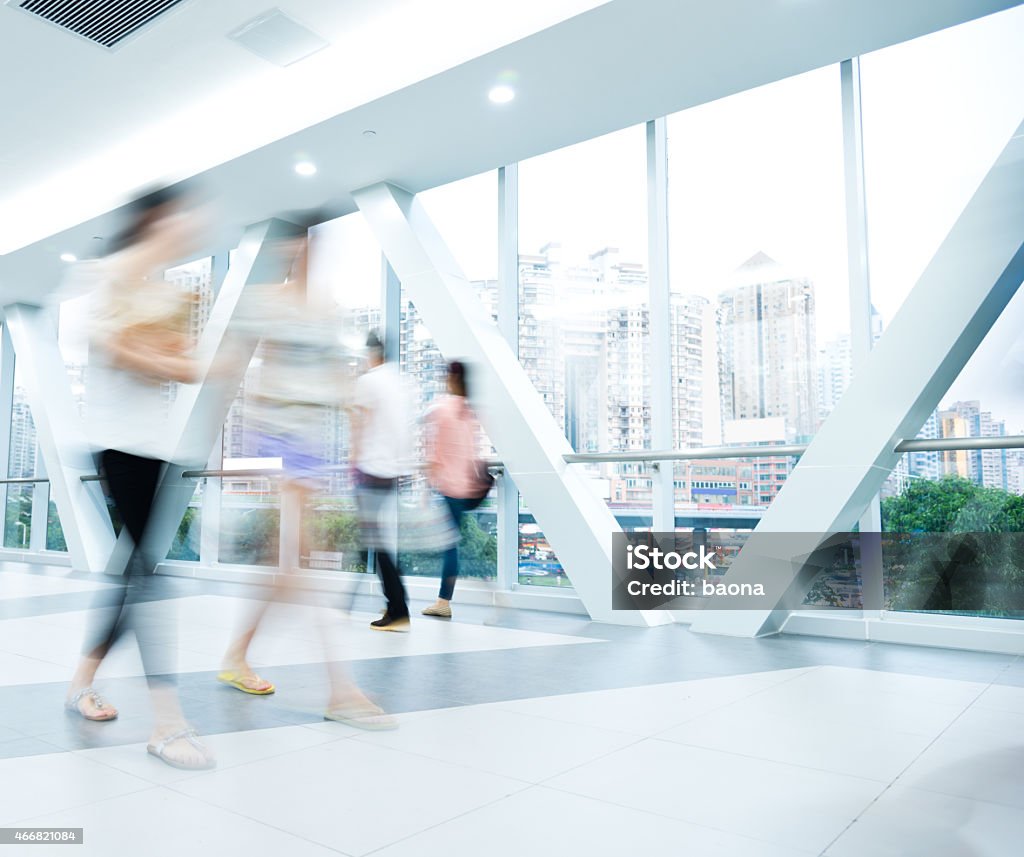 motion blurred people blurred and defocused people walking in the mall lobby. Blurred Motion Stock Photo