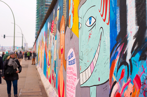 Berlin - Nov 15, 2014: Unidentified people walking and looking at the Berlin Wall at East Side Gallery.
