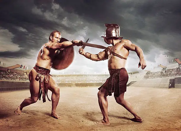 Gladiators fighting with sword on the sandy arena of the Colosseum under dramatic sky