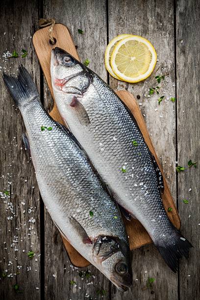 istock two raw seabass on cutting board with lemon 466823972