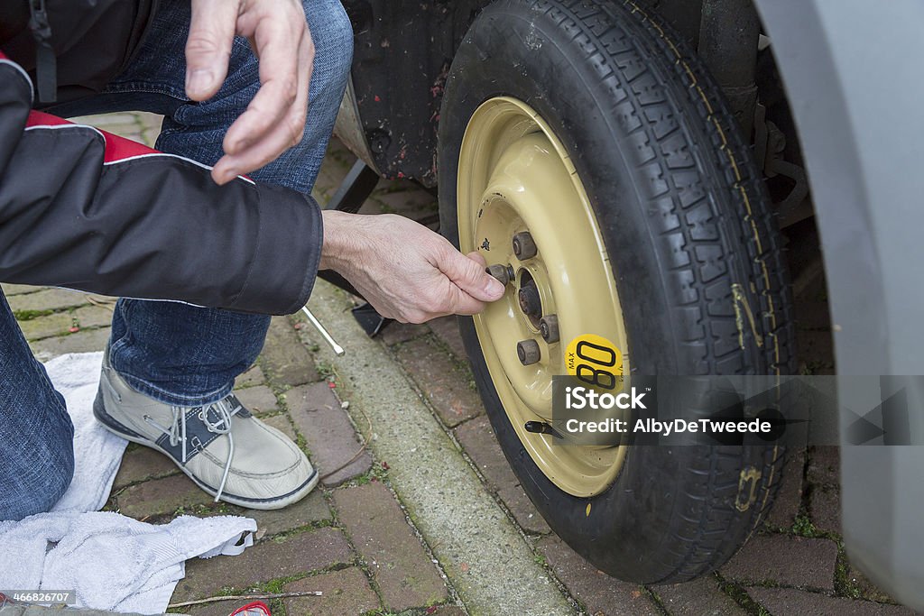 Dutch man changes a wheel because of flat tyre Dutch man changes a wheel because of a flat tyre Auto Mechanic Stock Photo