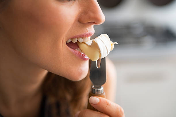 closeup on young woman eating camembert - cheese stockfoto's en -beelden