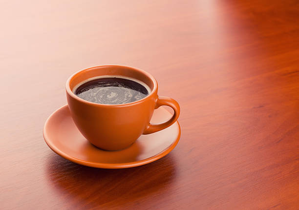 Paris, France: Brown and Yellow Cup/Saucer on Wood Table
