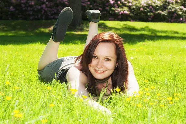 A beautiful young girl lying on the grass