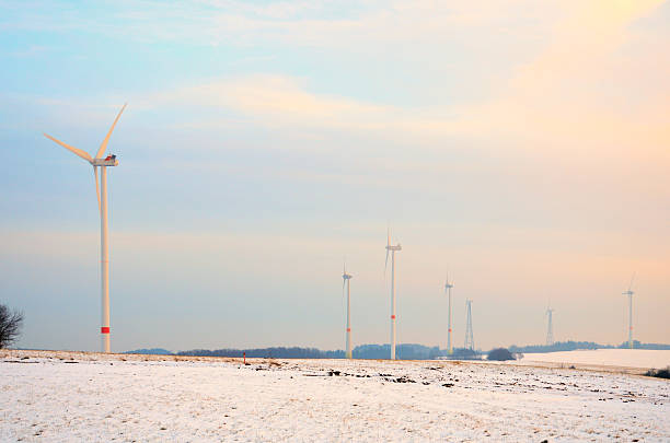 istock Wind turbines on field with snow at sunset 466832759