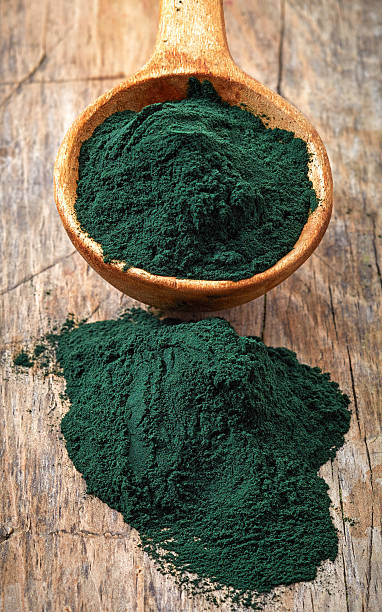 istock Wooden spoon of spirulina algae powder 466835088
