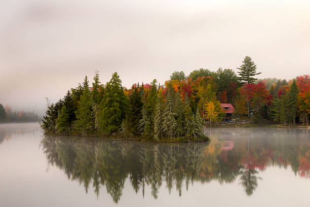 istock Island hides cottage surrounded by fall reflections of pines, maples 466836294