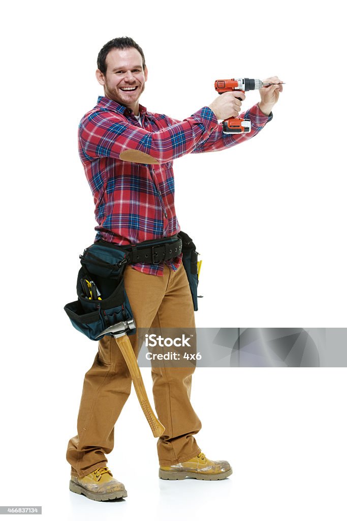 Smiling carpenter working with drill Smiling carpenter working with drillhttp://www.twodozendesign.info/i/1.png Drill Stock Photo