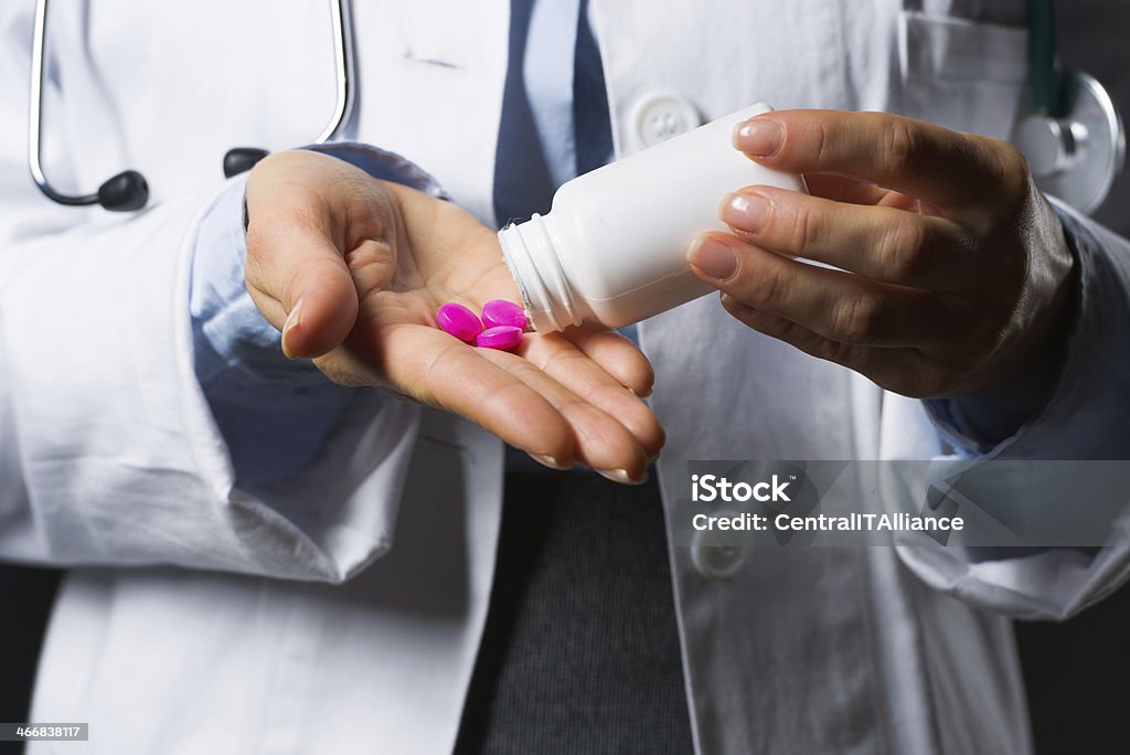 closeup on medical doctor woman empty medicine bottle in hand Closeup on medical doctor woman empty medicine bottle in hand Adult Stock Photo