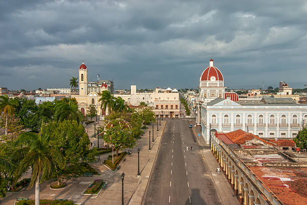 CIENFUEGOS, CUBA -  MAY 5: Aerial view to Jose Marti park with Town Hall and Cathedral of the Immaculate Conception lit by evening sun under heavy clouds shown on 5 May 2008 in Cienfuegos, Cuba