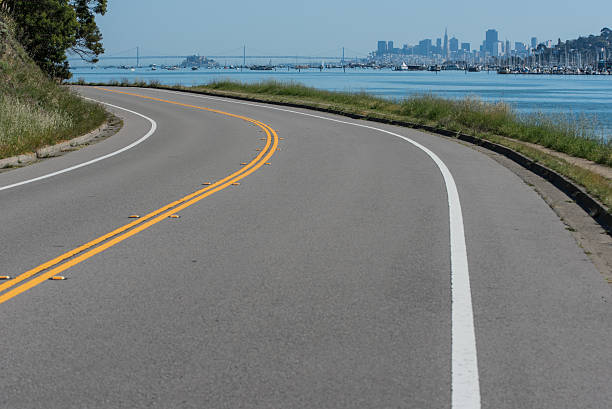 istock Curved road with double yellow and water 466838828