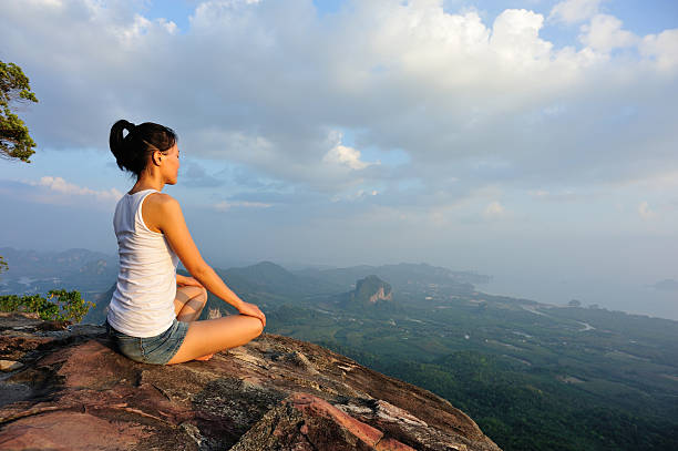istock Fit woman meditating on a mountain peak cliff 466842812
