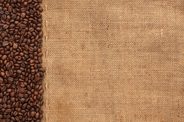 coffee beans лежать на sackcloth - coffee bag coffee bean canvas стоковые фото и изображения