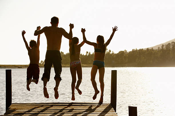 istock Family Jumping Off A Jetty 466853012