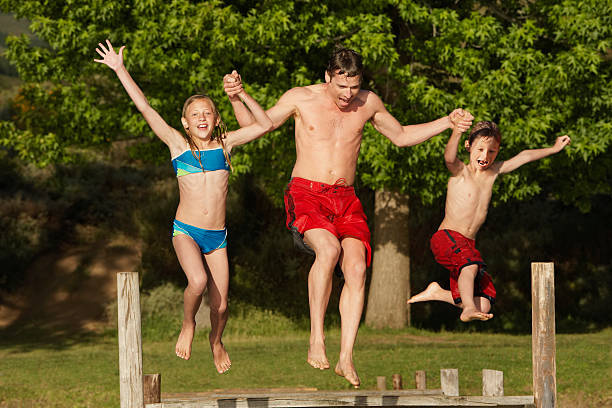 istock Family Jumping into Lake 466853030