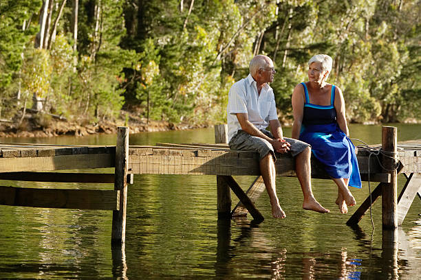 istock Senior Couple Sitting On Pier At Lake 466853032