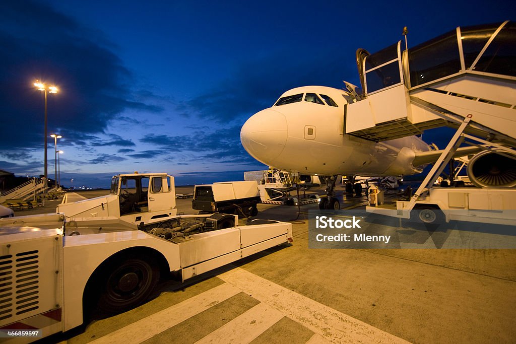 Nightflight Airplane at the Airport Airbus 320 Airplane getting prepared for the Nightflight. Ambient Airport Neon Light in the Twilight. Air Vehicle Stock Photo