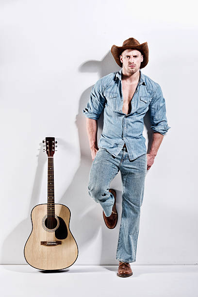 istock Muscular man leaning against wall with guitar 466867926