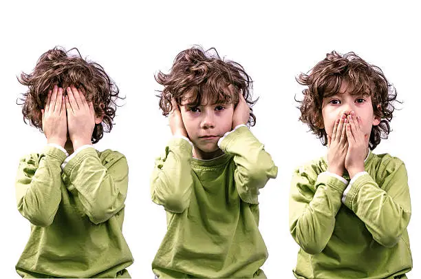 A young boy making the "See no Evil, Hear no Evil, Speask no Evil"