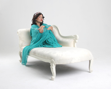 Adult arabian woman in abaya on sofa