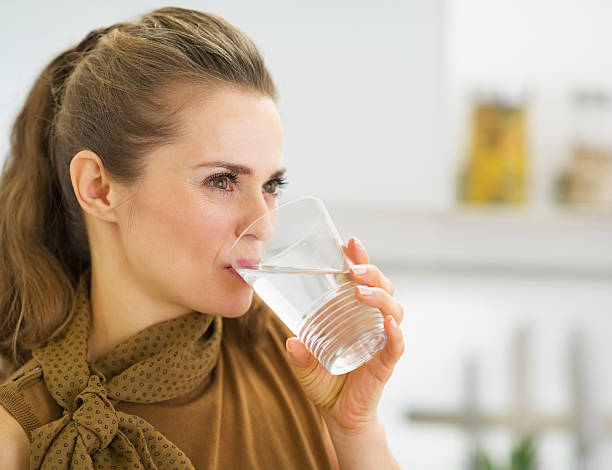 istock young housewife drinking water in kitchen 466880555