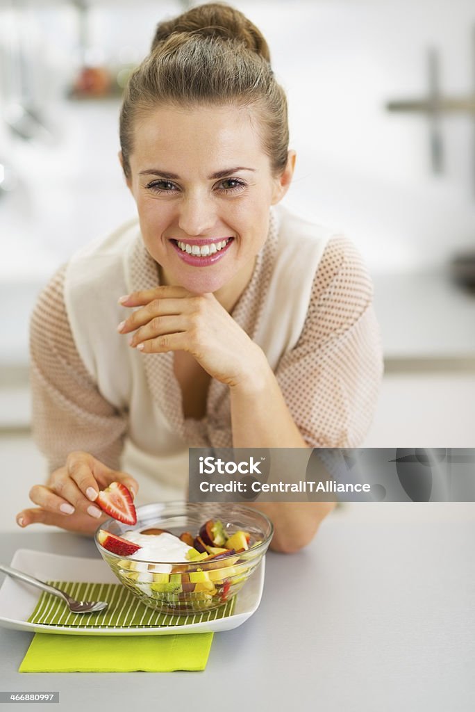happy young housewife decorating fruits salad Happy young housewife decorating fruits salad Adult Stock Photo