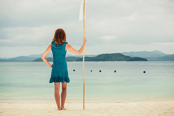 istock Woman on tropical beach with flag 466886648