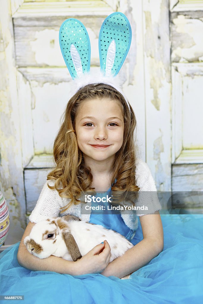 Bambina con orecchie da coniglio e un coniglietto tenendo - Foto stock royalty-free di Bambine femmine