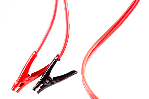Red and black jumper cables on white background.  Cord to clamps is red.