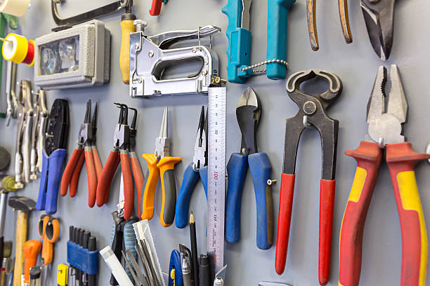 Tools hanging on the board Set of different tools hanging on grey background hardware store photos stock pictures, royalty-free photos & images
