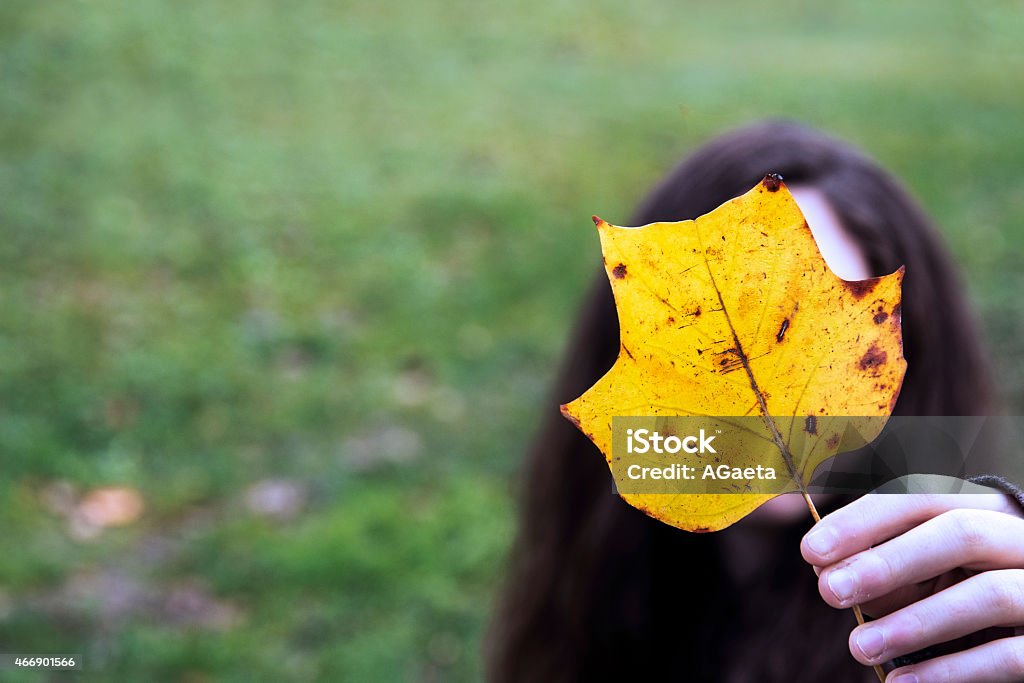 Autumn, Leaf, Adolescence A girl covers her face with a leaf. Loneliness Stock Photo