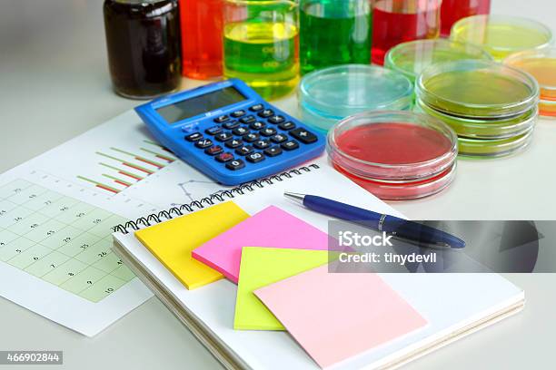 Calculator And Chart With Colorful Fluid In Glassware Stock Photo - Download Image Now