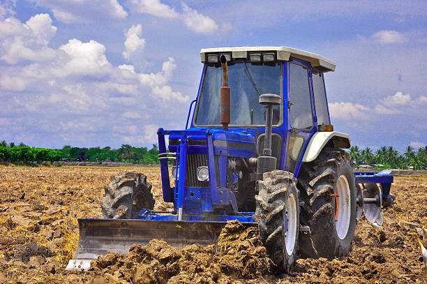 istock big tractor shoveling on the rice field 466917808