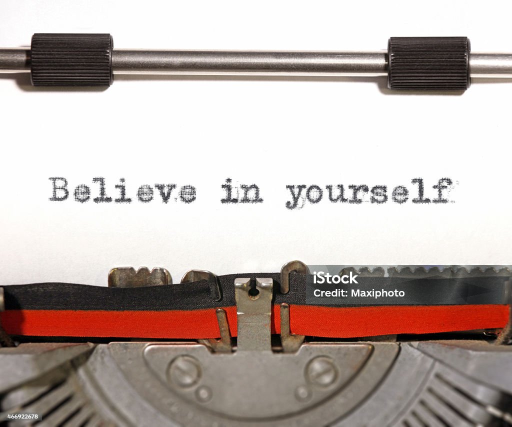 Believe in yourself: motivational quote on old typewriter machine Believe in yourself: motivational quote on a white page with a vintage typewriter detail. Positive thinking, incentives, self confidence and inspiration for life. 2015 Stock Photo