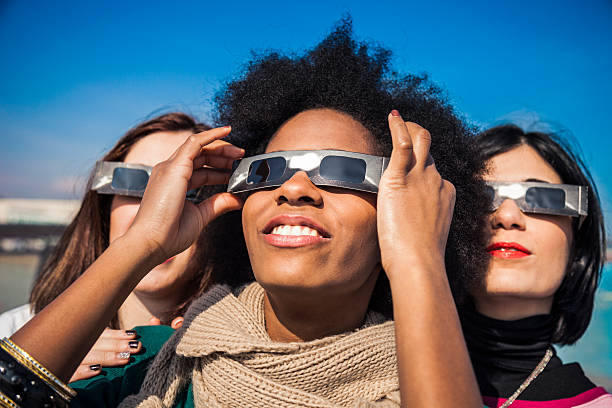 istock Group of friends looking to a solar eclipse 466925220