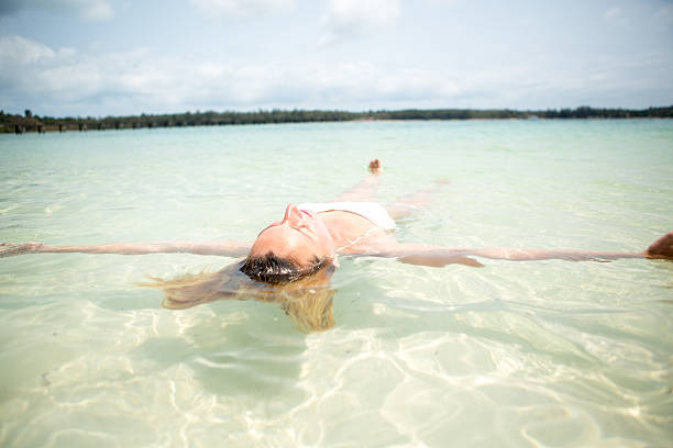 istock Woman floating on water relaxing and sunbathing 466926800