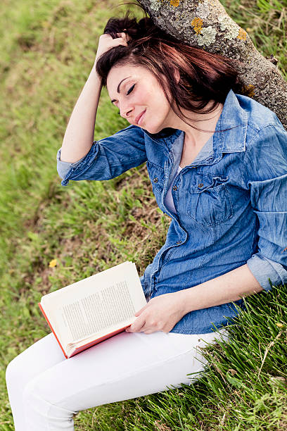 istock Woman reading a book at the park 466928679