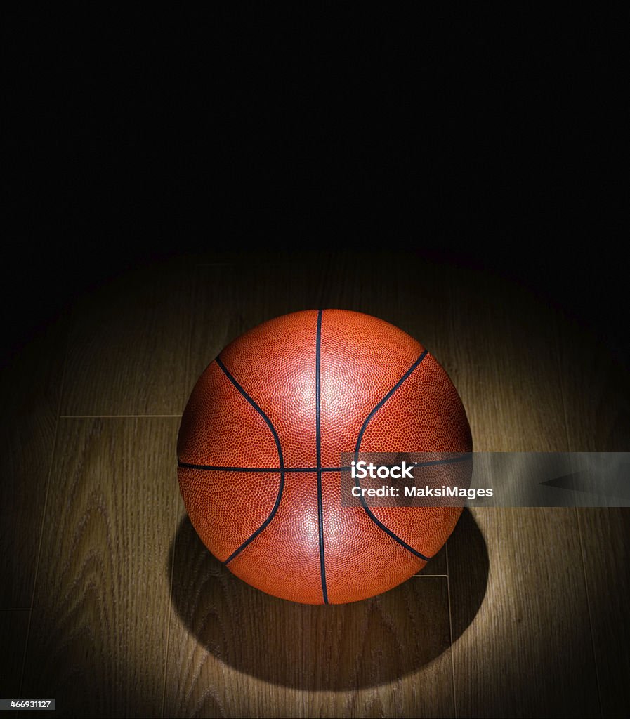 Spotlighted básquetbol solitario en un gimnasio en el piso - Foto de stock de Baloncesto libre de derechos