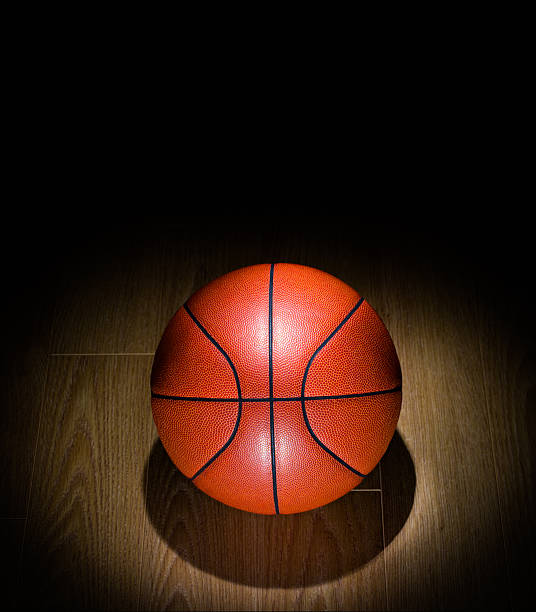 Spotlighted Basketball lonely on a Gym Floor stock photo