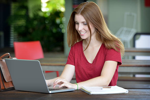 istock Beautiful female student sitting and working on a laptop computer 466932110