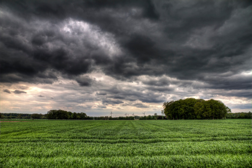 Ominous clouds over green fields in europe. HDR