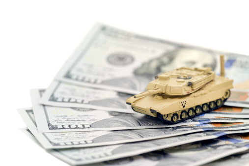 A United States tank on one hundred dollar bills. Can represent military spending, investment or waste.